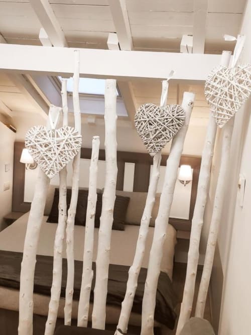 Rami di betulla bianca con decorazioni a cuore intessute sospese alle travi del soffitto nella loft TuffonelBlu, Ventimiglia