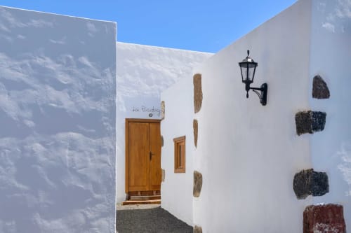 White-washed entrance to Finca de La Geria in Yaiza with wooden door and rustic details
