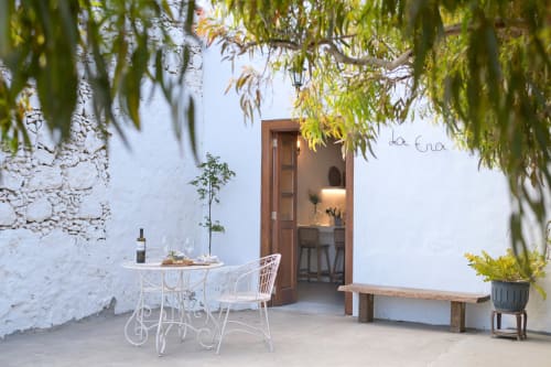 Courtyard seating area at Finca de La Geria in Yaiza with white furniture, wooden bench, and cascading greenery