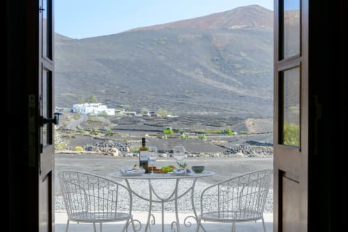 Outdoor terrace at Finca de La Geria with wine and table overlooking volcanic landscape in Yaiza