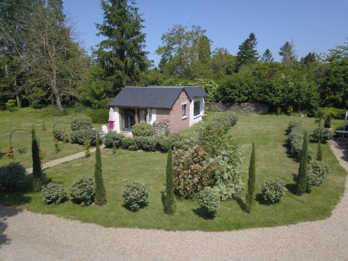 Clairseine cottage garden in Tournedos-sur-Seine with manicured landscaping and brick lodge surrounded by lush trees