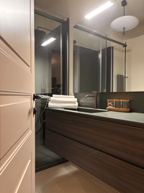 Bagno moderno al B&B Delta Majestic di Pordenone con vanità scura, ampio specchio e accessori contemporanei