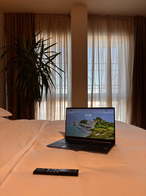 Laptop nero su tavolo in legno nella camera B&B Delta Majestic con vista sulla città, Pordenone