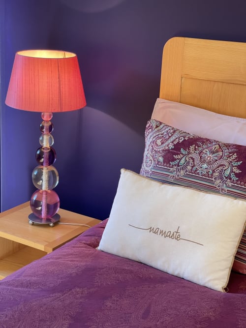 Chambre douillette au gîte Entre Terre Et Ciel à Rémuzat avec literie violette, lit en bois et lampe rouge