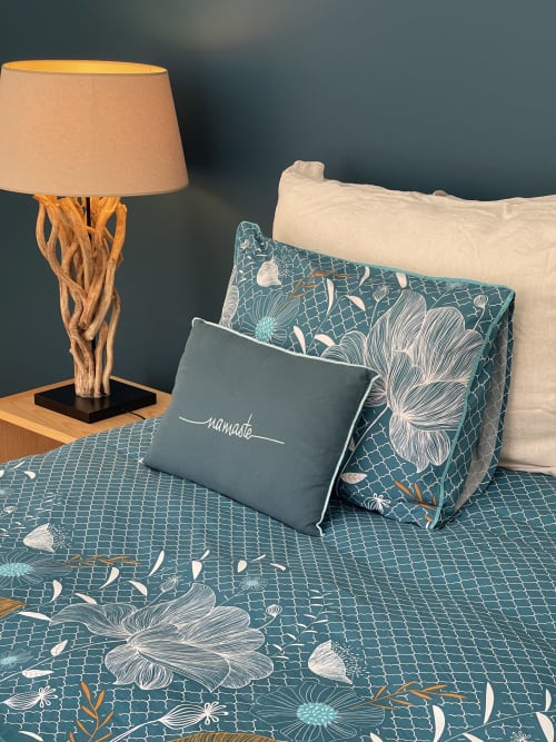Chambre douillette à Entre Terre Et Ciel avec literie fleurie bleu canard, coussins décoratifs, lampe en bois et mur bleu canard foncé à Rémuzat