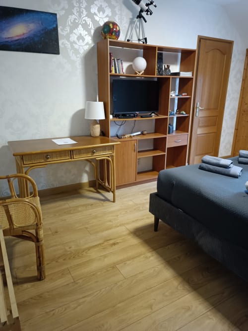 Chambre moderne de l'hôtel CafecouetBreizh à Guipry-Messac avec mobilier en bois, téléviseur, bureau et vue sur le jardin