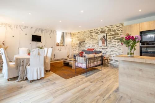 Geräumiges Ferienhaus-Interieur in Les logis de Kergoulou in Concarneau mit Steinwänden, offener Küche und Esszimmer