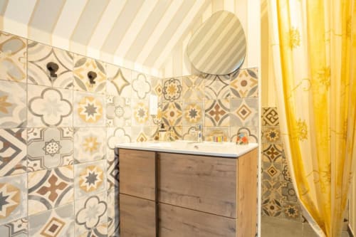 Helles Badezimmer in der Gîte Le Penty des Les logis de Kergoulou in Concarneau mit gemustertem Fliesenbelag und Holzwaschtisch