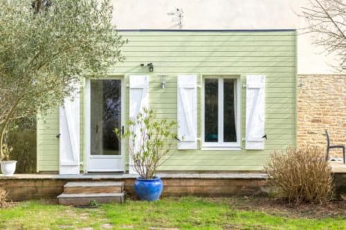 Charming green cottage with white shutters and garden patio at Les logis de Kergoulou in Concarneau