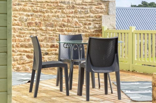 Modern black wicker chairs on wooden deck at Les logis de Kergoulou cottage in Concarneau