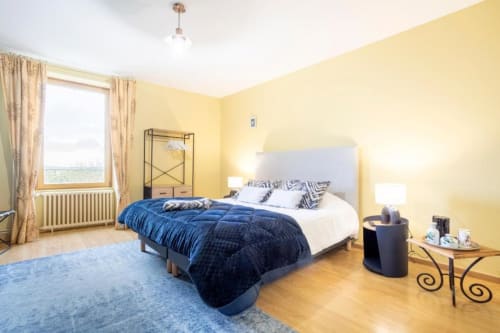Chambre lumineuse jaune vif aux touches bleues à Les logis de Kergoulou B&B à Concarneau, avec lit queen-size, vue jardin et