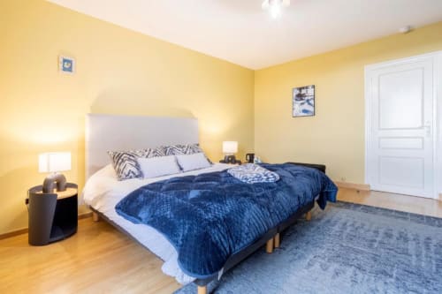 Bright yellow bedroom with blue quilted bedding at Les logis de Kergoulou B&B in Concarneau, France