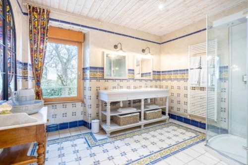 Spacious bathroom in Madame de la Fayette room at Les logis de Kergoulou, Concarneau, with blue and white tilework, dual
