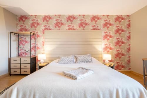 Elegant bedroom at Les logis de Kergoulou in Concarneau with floral wallpaper, queen bed, and garden view