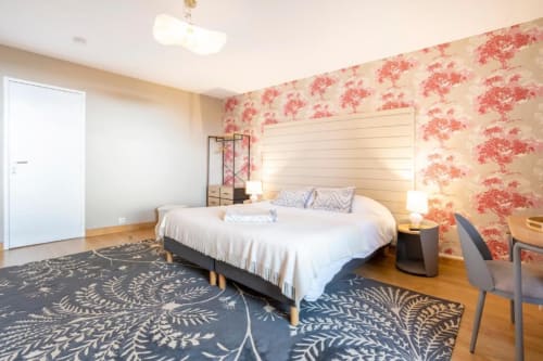 Anne de Bretagne suite at Les logis de Kergoulou in Concarneau, with floral wallpaper, cream headboard, and garden view