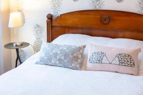 Cozy bedroom at Les logis de Kergoulau B&B in Concarneau with wooden headboard, white bedding, and patterned pillows