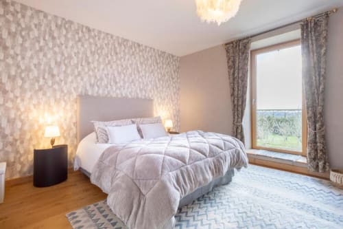 Elegantes Schlafzimmer in Les logis de Kergoulou B&B in Concarneau mit gemusterter Tapete, Queensize-Bett und Gartenblick