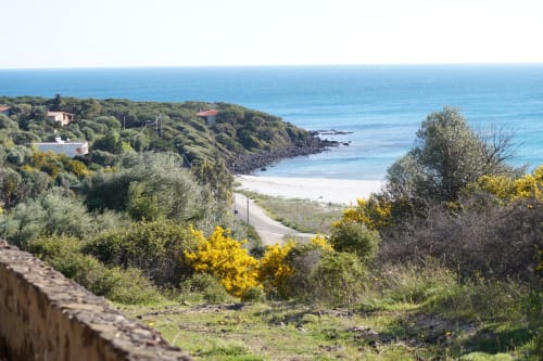 Orosei villa with sea view overlooking Mediterranean coastline, white sandy beach, and lush vegetation