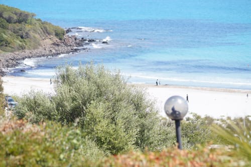 Coastal villa in Orosei with sea view, sandy beach, rocky cliffs and Mediterranean vegetation.