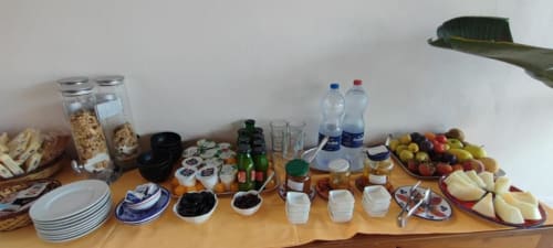 Buffet colazione all'Hotel Principe di Rinella con pani, cereali, olive, formaggi e bevande