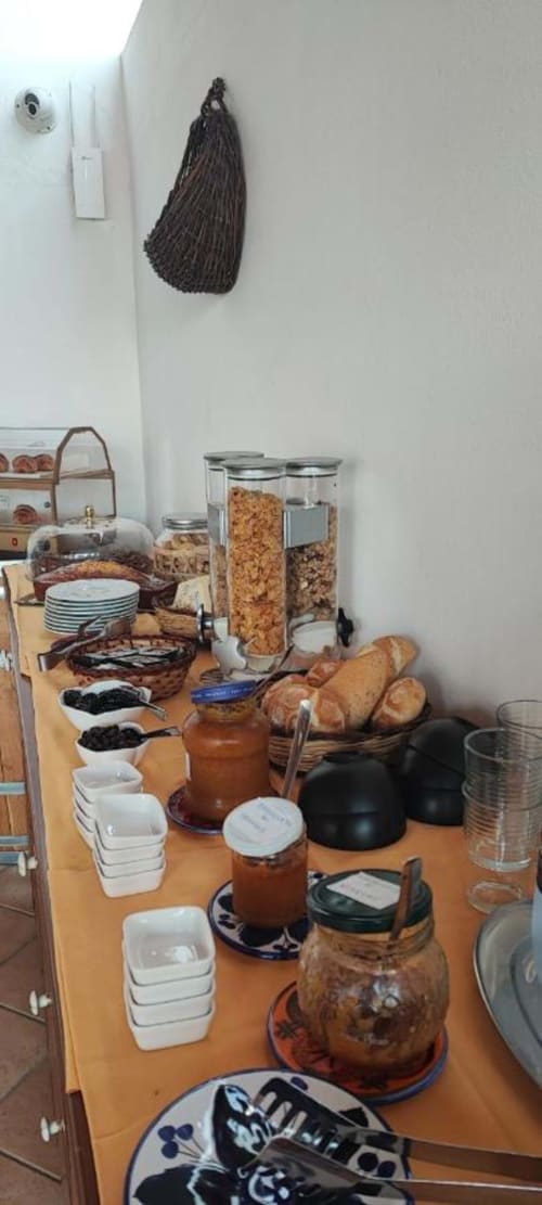 Esposizione cucina all'Hotel Principe di Rinella con cereali, pane, ciotole e tradizionali utensili da cucina