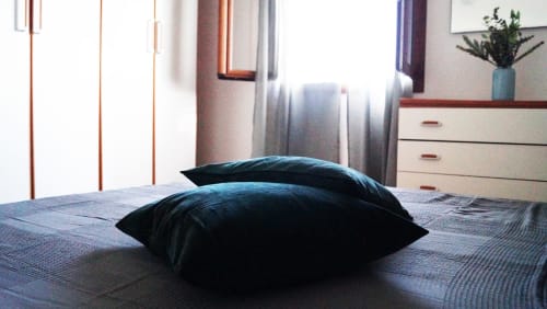 Modern bedroom with dark pillows on bed, sea-view villa in Orosei, Domo Sara with contemporary furnishings and natural light