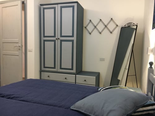 Bedroom in Sa Tanca De su Catreathu villa, Orosei with blue bed, wardrobe and standing mirror