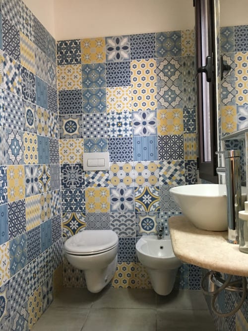 Colorful patterned tile bathroom with toilet and bidet at Sa Tanca De su Catreathu villa in Orosei