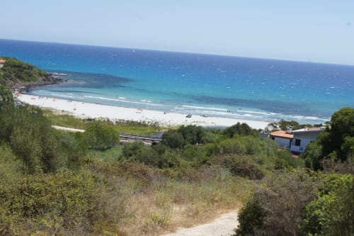 Pristine white sand beach with turquoise waters in Orosei, Italy, coastal villa property with Mediterranean vegetation and