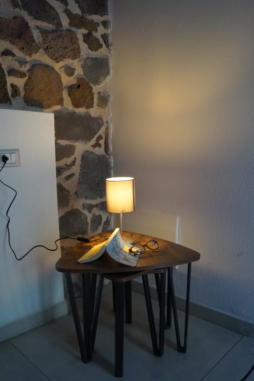 Angolo accogliente con lampada gialla illuminata su tavolo scuro nella villa Sa Domo De Mannoi, Orosei
