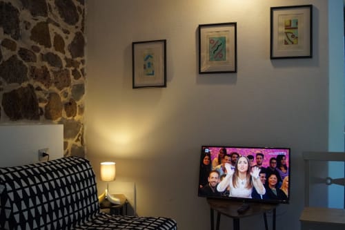Camera da letto di una villa moderna a Orosei con biancheria decorata, arte astratta incorniciata, TV a schermo piatto e illuminazione calda