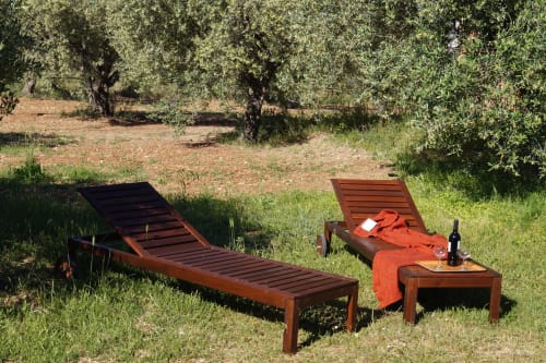 Two wooden sun loungers with orange towels in olive garden setting at Orosei villa