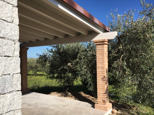 Modern pergola with brick support column overlooking olive trees and garden at Sa Tanca De Mannoi villa in Orosei