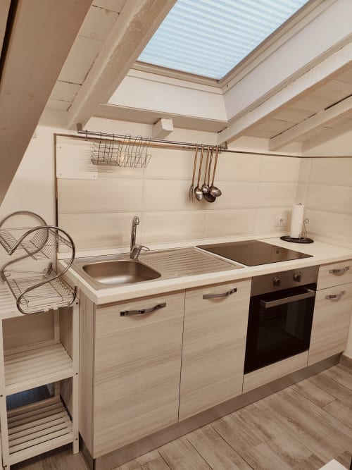 Cucina moderna nel loft TuffonelBlu a Ventimiglia con lucernario, lavello in acciaio, forno e mobili in legno