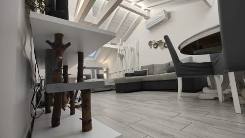 Interno moderno di loft a TuffonelBlu a Ventimiglia con lucernario, arredamento in legno, divano nero e pavimenti in piastrelle