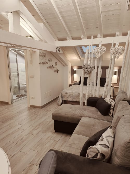 Moderno loft a Ventimiglia con letto a baldacchino, divano, travi a vista e living open-plan
