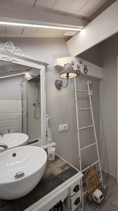 Bagno moderno nel loft TuffonelBlu a Ventimiglia con lavabo bianco, doccia, scala decorativa e parete a forma di cuore