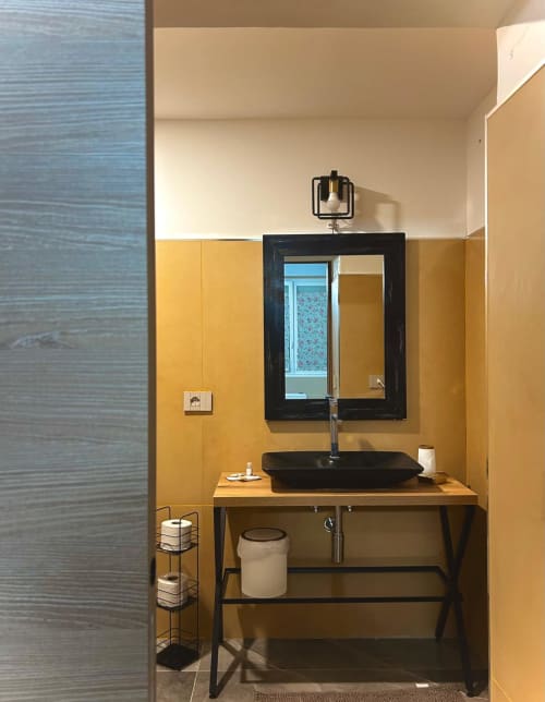 Vanity bagno moderno a San Carlo 104 a Caserta con lavabo nero e specchio incorniciato su parete con piastrelle gialle