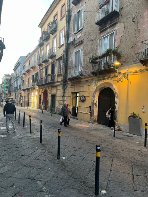 Storica via di Caserta con edifici colorati, pavimentazione in ciottoli e dissuasori vicino all'hotel San Carlo 104