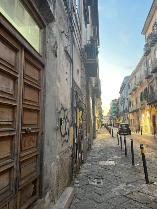 Affascinante via lastricata a Caserta con edifici storici e persiane gialle, vista della città dal BnB San Carlo 104