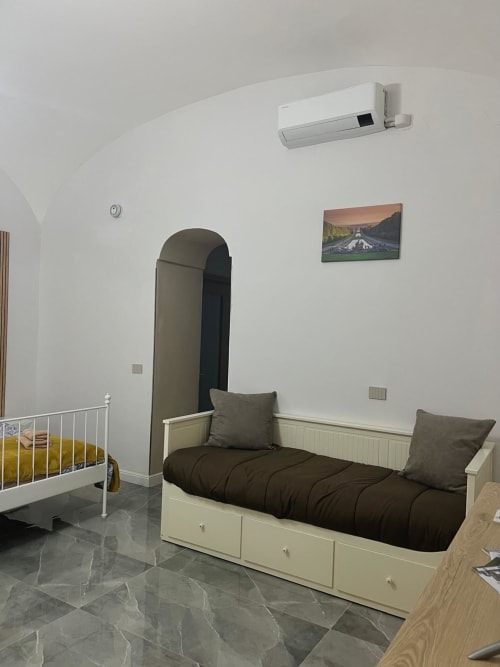 Camera moderna a San Carlo 104 a Caserta con letto, culla, aria condizionata e quadri paesaggistici