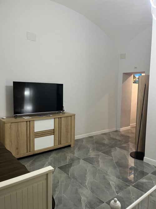 Camera 102 a San Carlo 104 a Caserta con TV, arredamento in legno, pavimento in marmo e vista sulla città