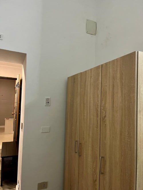 Camera 102 del San Carlo 104 B&B a Caserta con armadio in legno, prese elettriche e ingresso principale