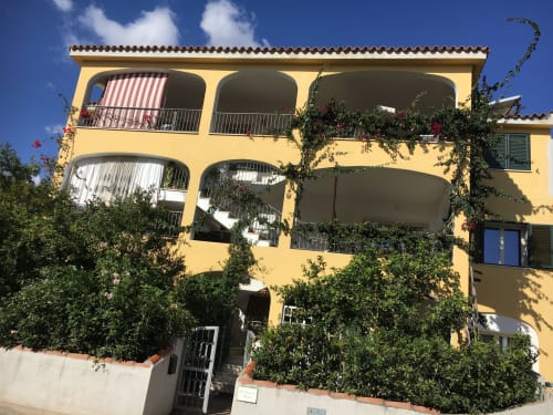 Bright yellow Italian villa with ivy-covered facade and spacious terraces in Orosei, Sardinia