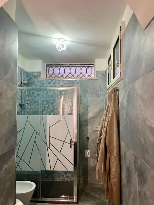Bagno moderno presso San Carlo 104 B&B a Caserta con box doccia e accenti in piastrelle turchesi