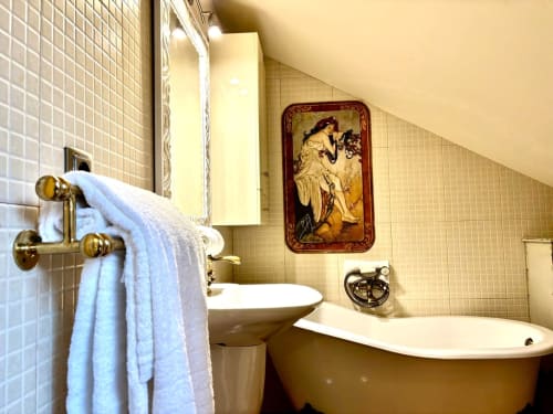 Baño elegante en apartamento Lembrare, Baiona con decoración vintage, toallas blancas, bañera y paredes de azulejos