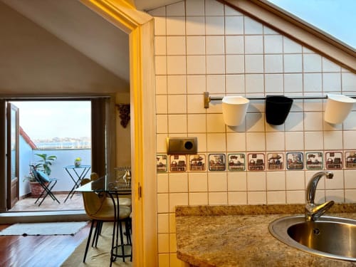 Cocina moderna con encimera de granito, ventana con vistas al mar y balcón frente al agua en apartamento de Baiona