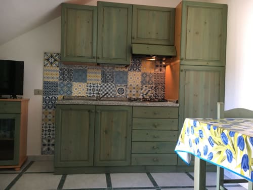 Cucina verde salvia con piastrelle decorate in Casa Arborea, sistemazione a Orosei