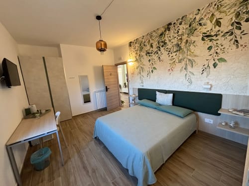 Camera moderna a La Dimora Di Ipno B&B a Vallata con carta da parati vista giardino, letto queen, scrivania e servizi