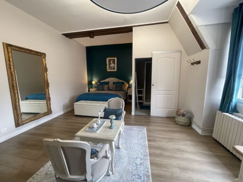 Suite spacieuse avec lit bleu, coin salon élégant et miroir, maison d’hôtes à Evry, Essonne, France, charme, confort, ambiance chaleureuse